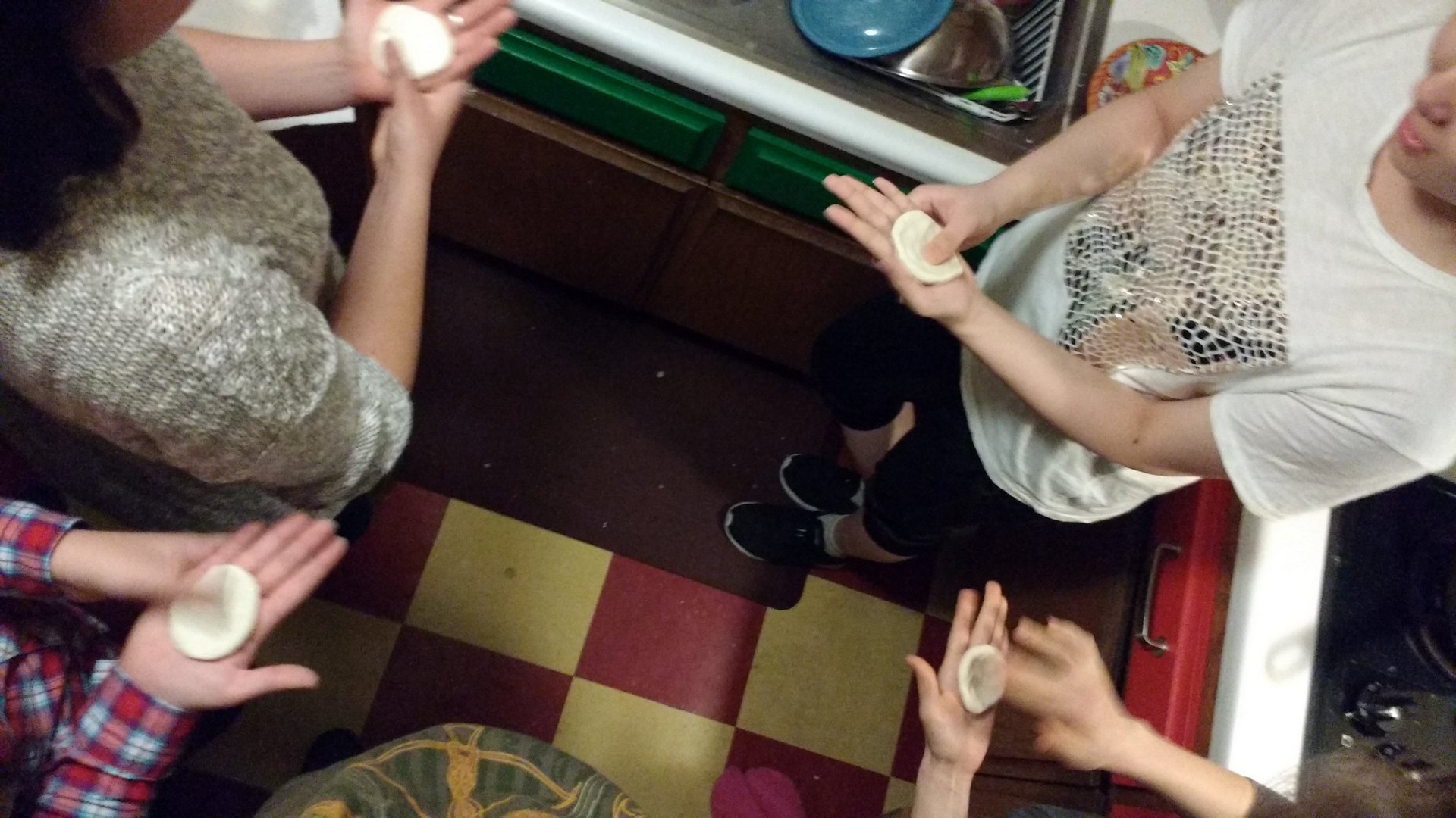 people in the kitchen preparing dough