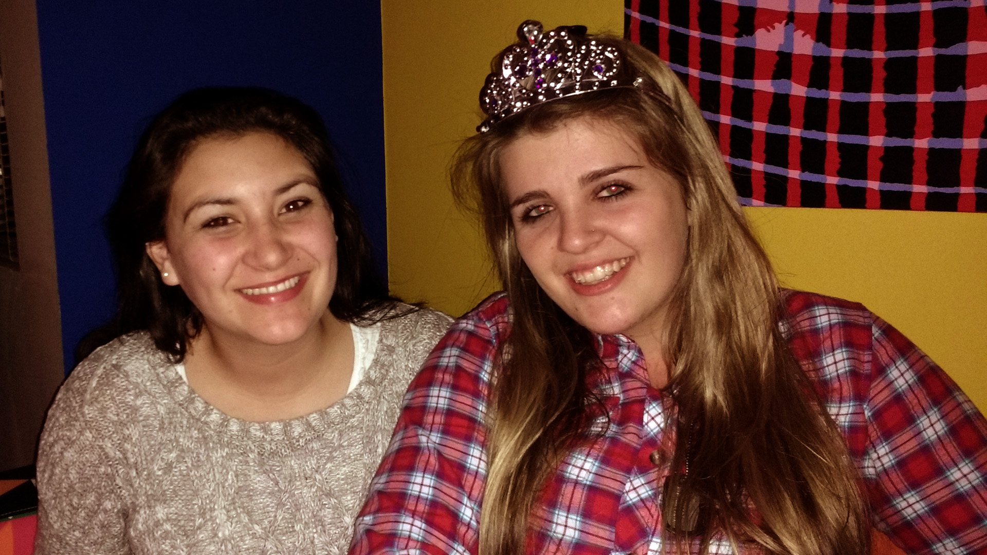 Celeste and Daleen sitting in the living room. Daleen wears a tiara.