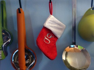 kitchen tools hanging from the wall, including a tiny christmas stocking with a "g" on it