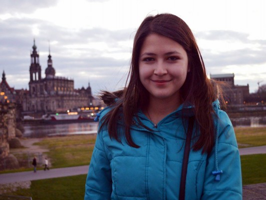 Aylar in a winter coat standing in front of a Dresden panorama