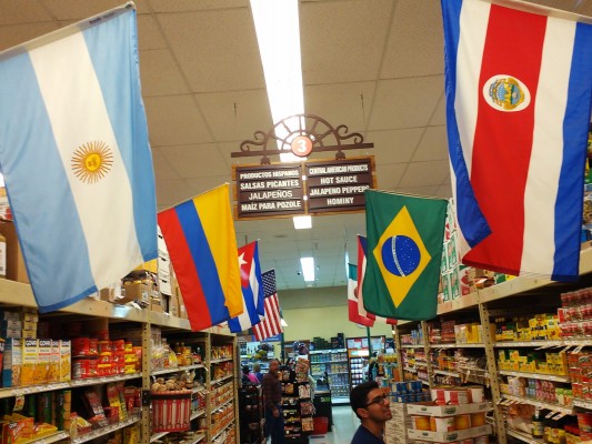 Davis in a grocer market aisle, lined by the flags of Latin American countries