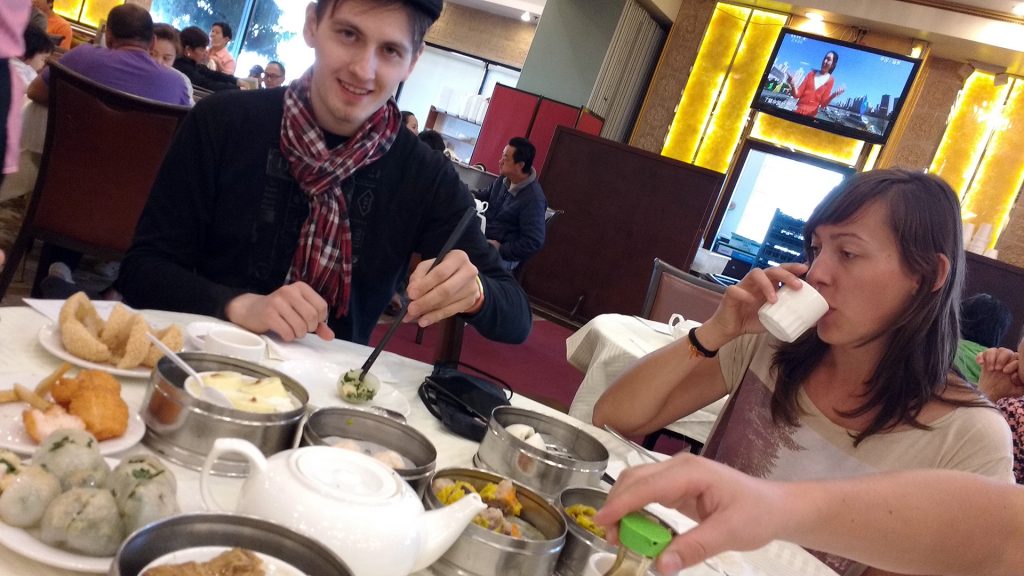 2 people seated at a table eating dim sum