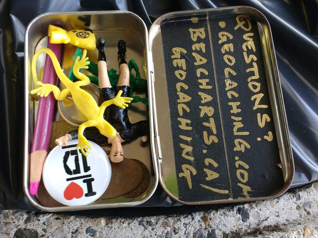 photo of the contents of a small geocache inside an Altoids tin