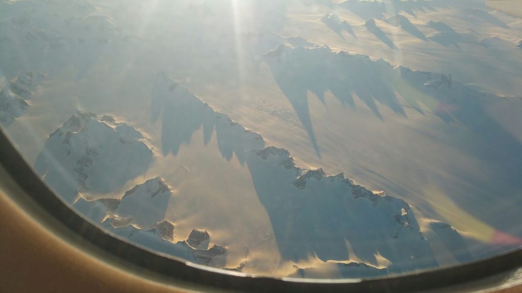 Photo of ice-covered Greenland out an airplane window