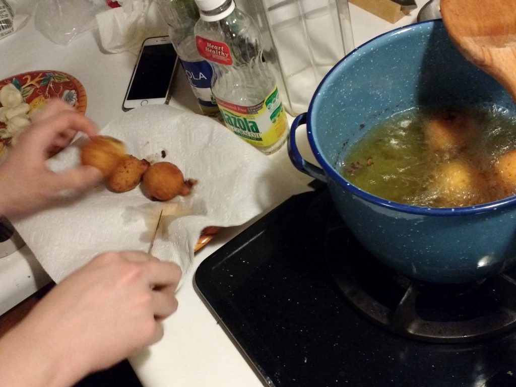 Soojeen cutting a donut in half to check if it's cooked