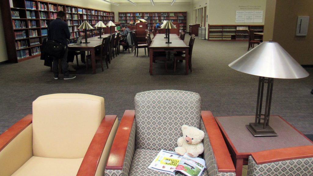 Ambyr Noelle with a magazine in a study area at the UNR library