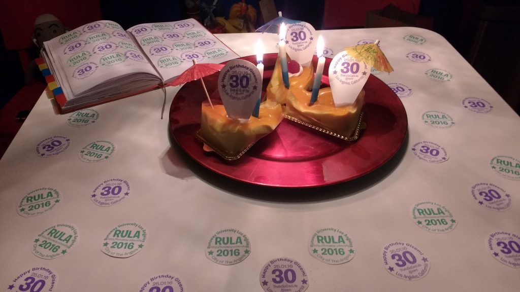 3 slices of dessert on a table. The table is decorated with logos for "RULA" and for "Gizem's 30th Birthday"