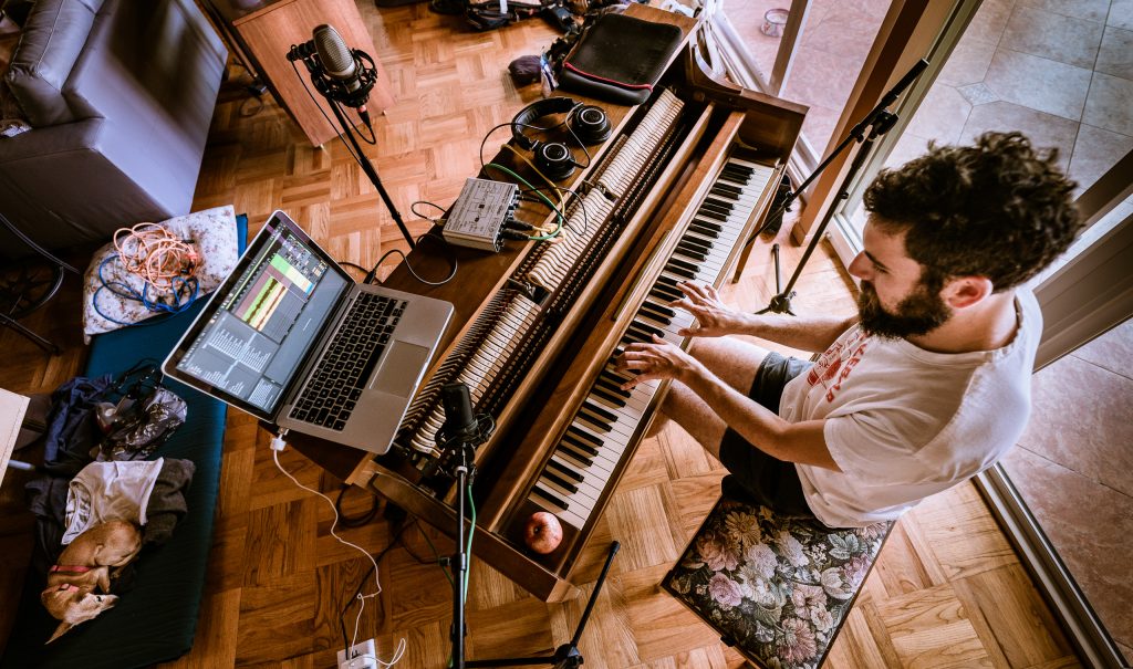 Tiki Brown listens as Benjamin Geyer plays piano