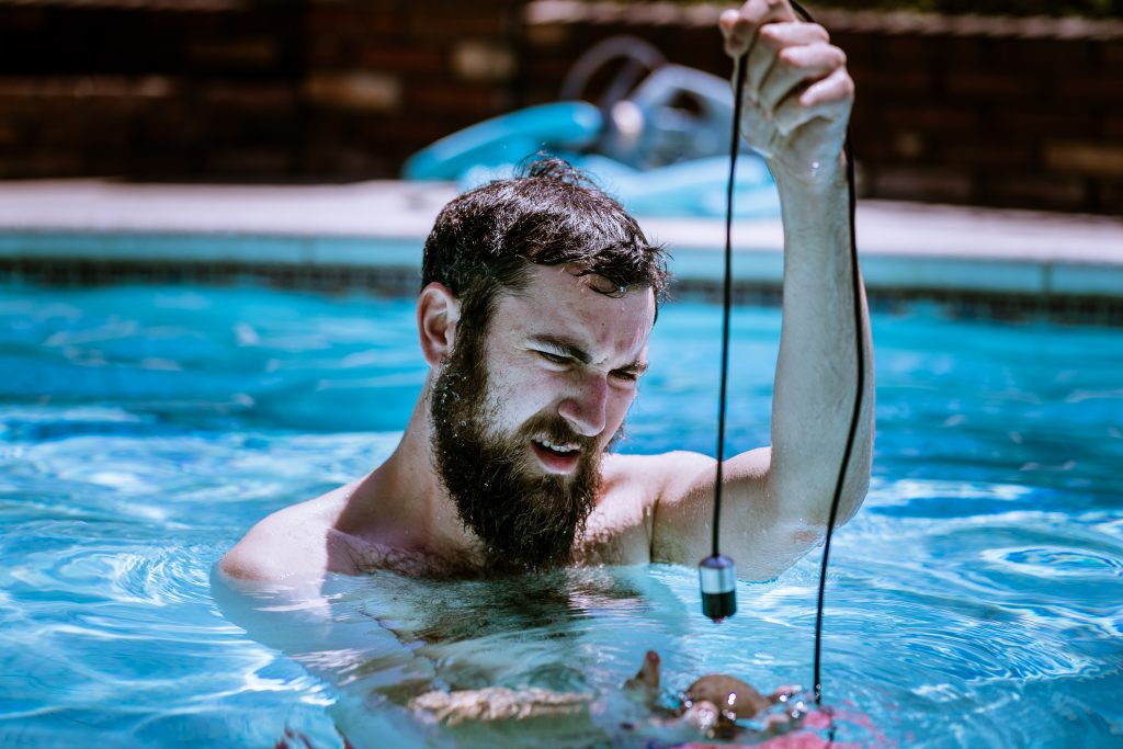 Benjamin Geyer recording sounds in a pool with a hydrophone