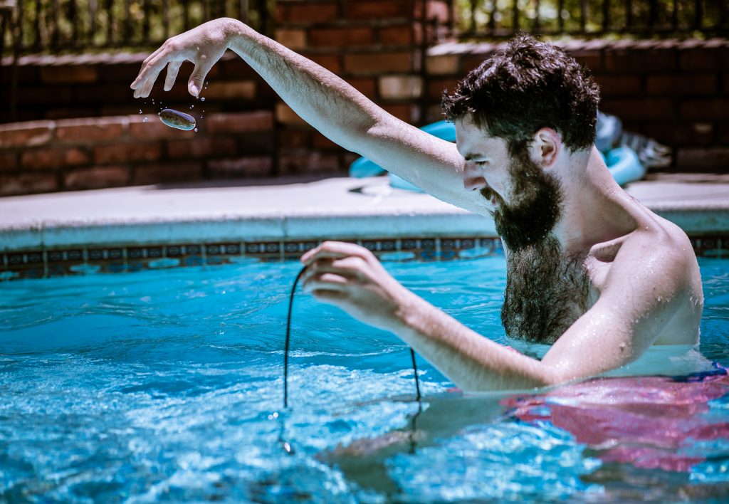 Benjamin Geyer recording sounds in a pool with a hydrophone