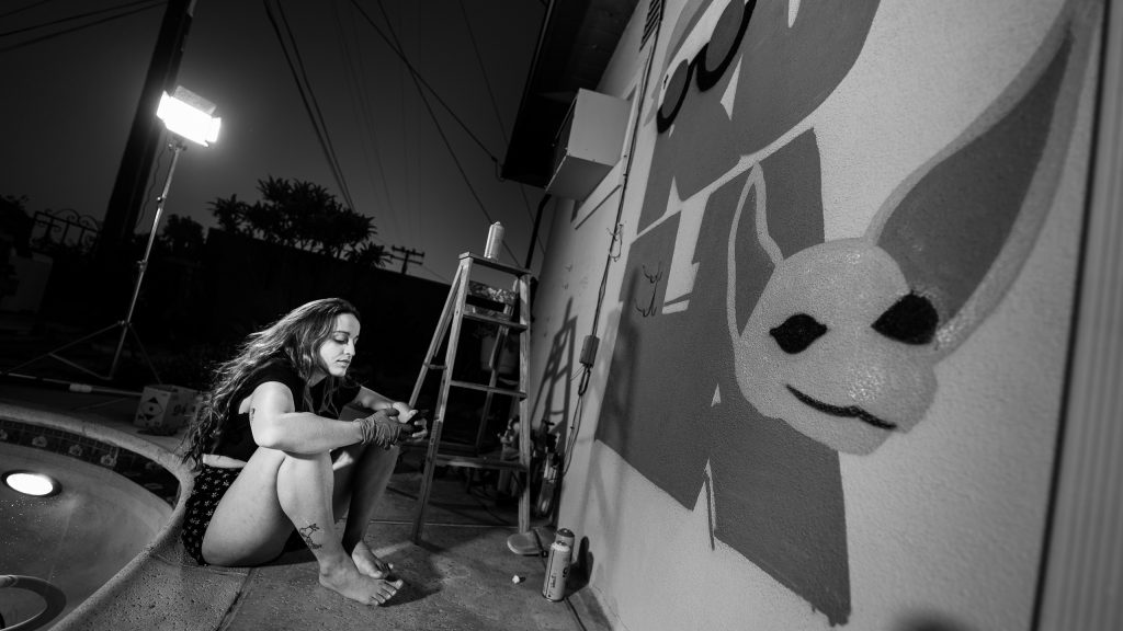 Merijein Saperas painting a graffiti writing mural of the letters "RULA" at Runaway University in Los Angeles, California.