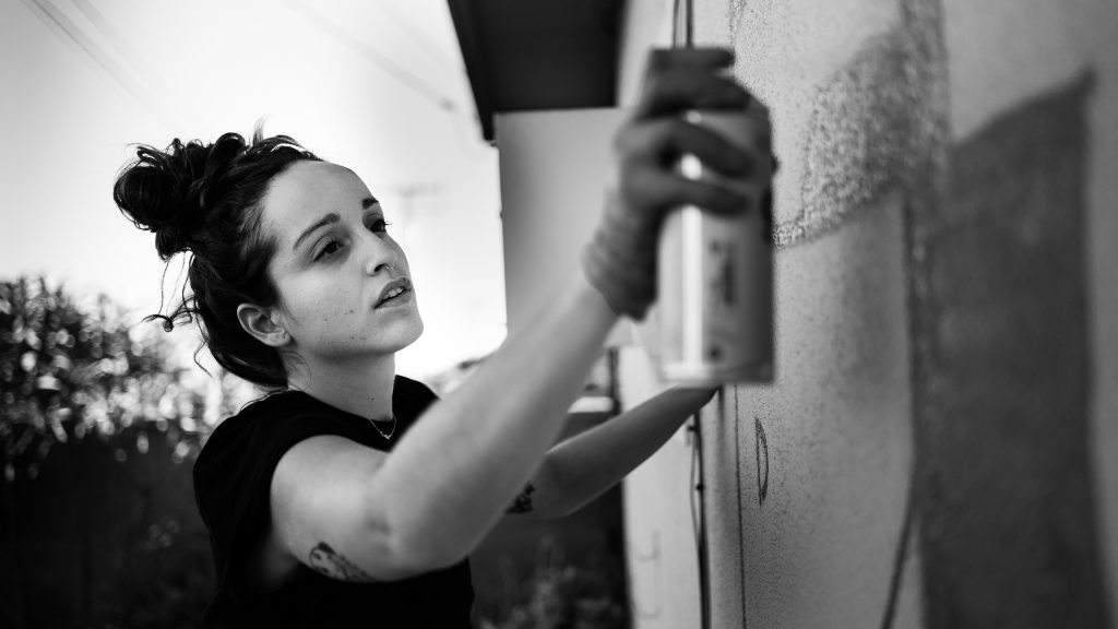 Merijein Saperas painting a mural on a wall using Montana 94 spray paint