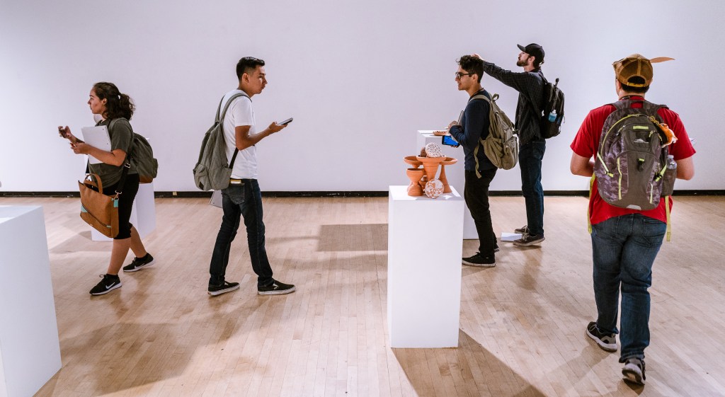 students in Long Beach State University's Gatov Gallery viewing an art installation