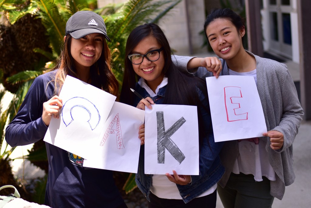 3 students holding the letters "C A K E"