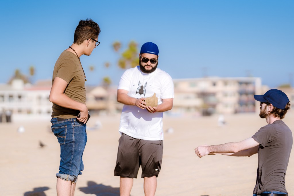 students creating plaster casting projects in the sand at the Seal Beach Pier