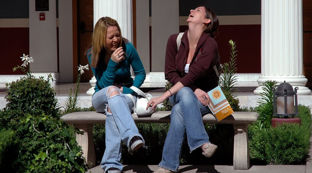 CSULB Students sitting on a bench and laughing at The Getty Villa in Malibu, CA