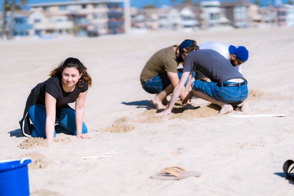 students creating plaster casting projects in the sand at the Seal Beach Pier