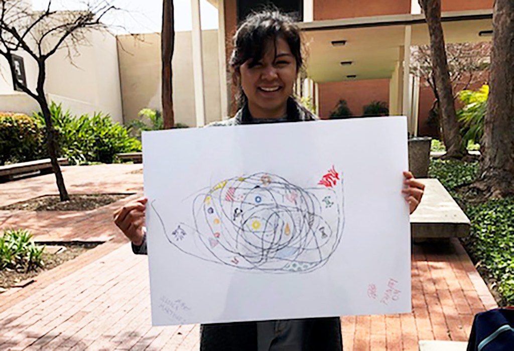 Phanary Om holding a large drawing and smiling