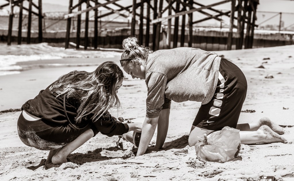 making a mold in the sand at the Seal Beach Pier